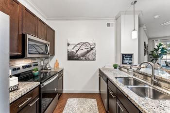 A kitchen with a black granite countertop and a white sink.